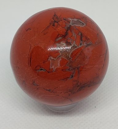 Boule rouge marbrée avec des nuances noires et argentées.